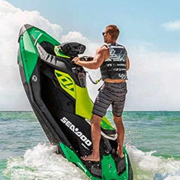 Man showing off tricks on Sea-Doo Spark Trixx by standing on his personal watercraft wearing Sea-Doo Life Vest in Fond du Lac, WI